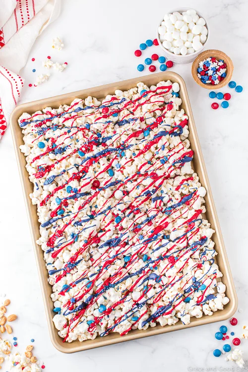 popcorn with red, white, and blue drizzle in a sheet pan