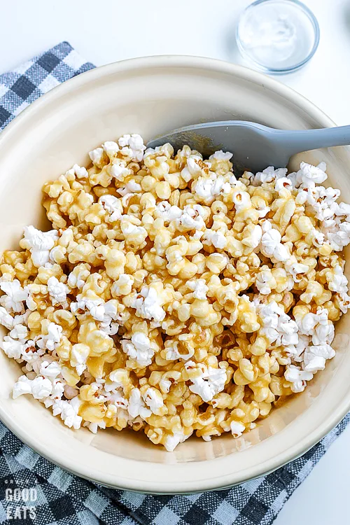 bowl of caramel corn with a spatula in it