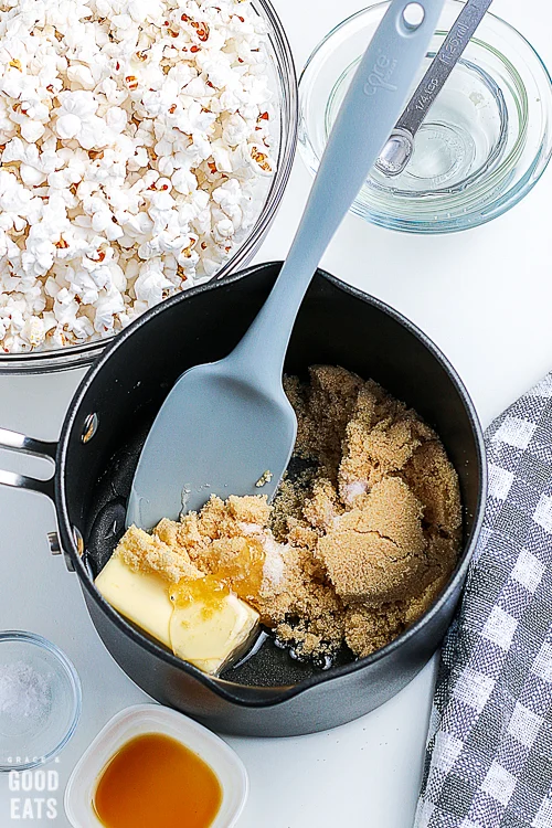 pot with butter and sugar next to a bowl of popcorn